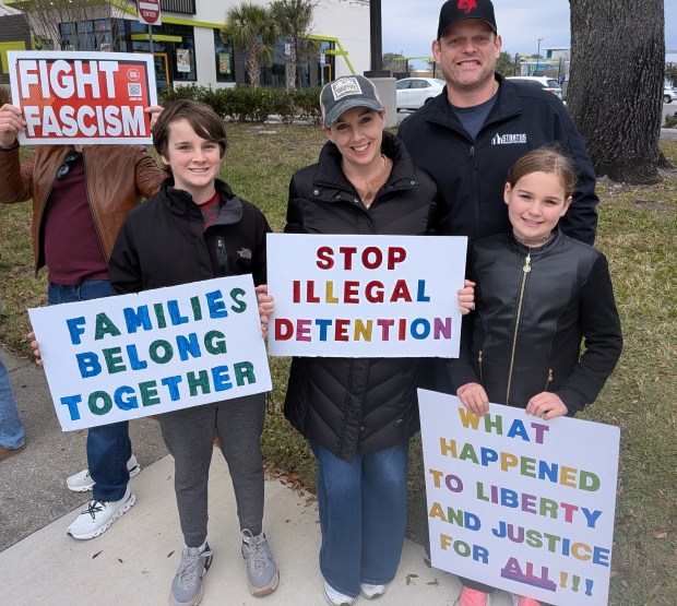 A couple brought their son, 11, and daughter, 9, to the Ice Out of Orlando protest Saturday, Jan. 31, 2026, along East Colonial Drive near Fashion Square Mall. The parents said they felt it was important for their children to learn about what's going on in the nation by experiencing it firsthand. (Brian Bell/Orlando Sentinel)