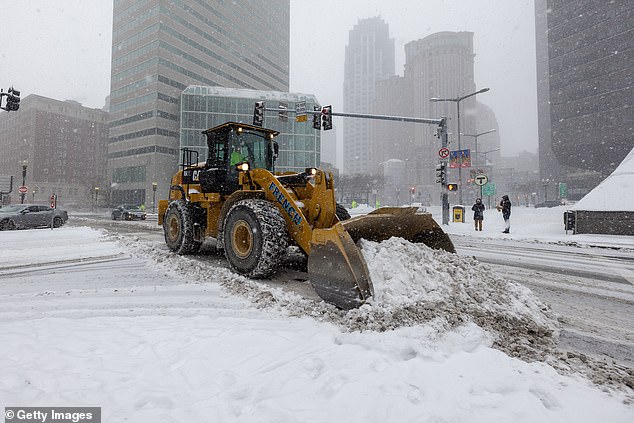 A snow plow is seen clearing the streets of Boston, Massachusetts on Sunday