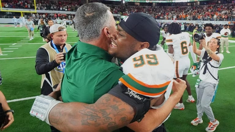 Miami head coach Mario Cristobal, left, hugs defensive lineman Ahmad...