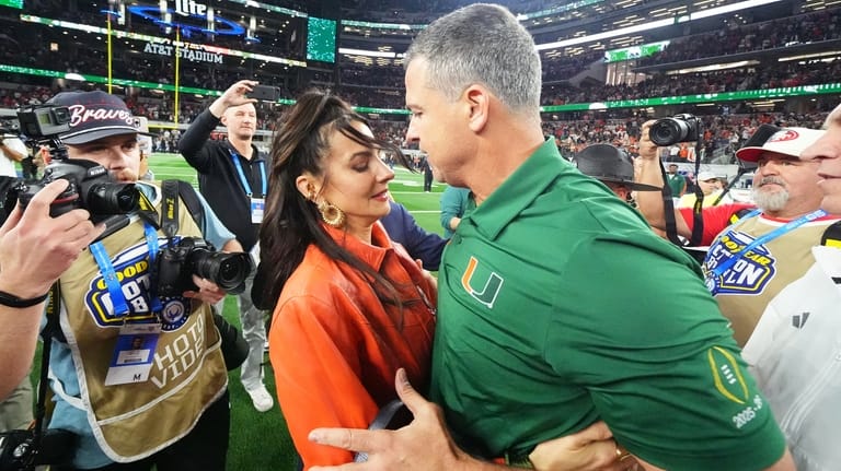 Miami head coach Mario Cristobal, right, talks to his wife,...