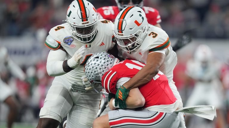 Ohio State quarterback Julian Sayin, center, is sacked by Miami...