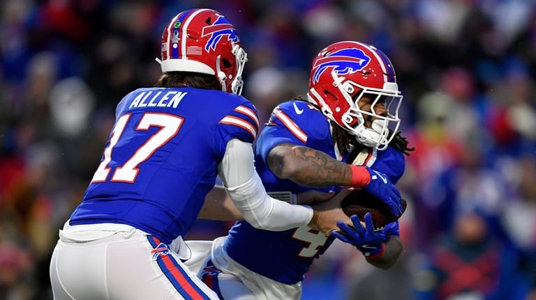 Buffalo Bills quarterback Josh Allen (17) hands off to running...