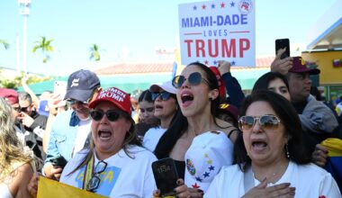 Photo of protesters singing at a rally. One woman wears a hat reading, "Women for Trump." A person in the back holds a sign reading, "Miami-Dade loves Trump"