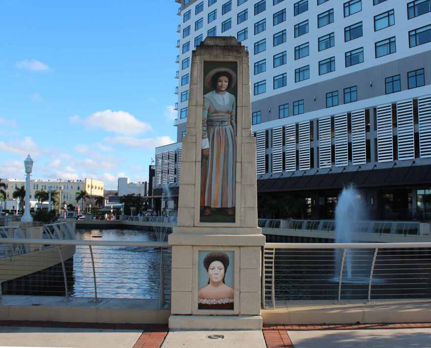 Mural of Dr. Ella Mae Piper on Edwards Ave with Luminary Hotel and river basin in background.