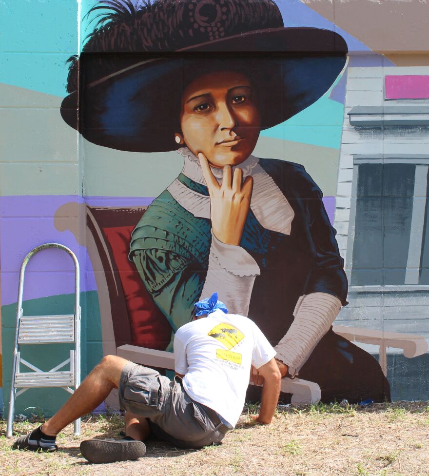 Muralist Roland Ruocco works on panel of Buck's Backyard Mural dedicated to Dr. Ella Mae Piper at McCollum Hall.