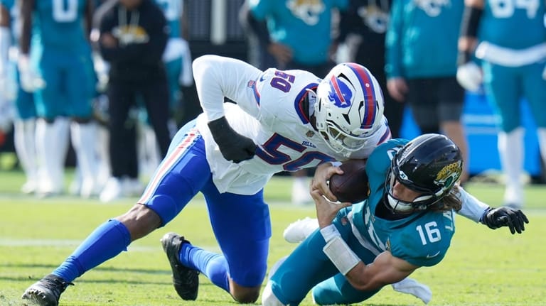 Jacksonville Jaguars quarterback Trevor Lawrence (16) is sacked by Buffalo...