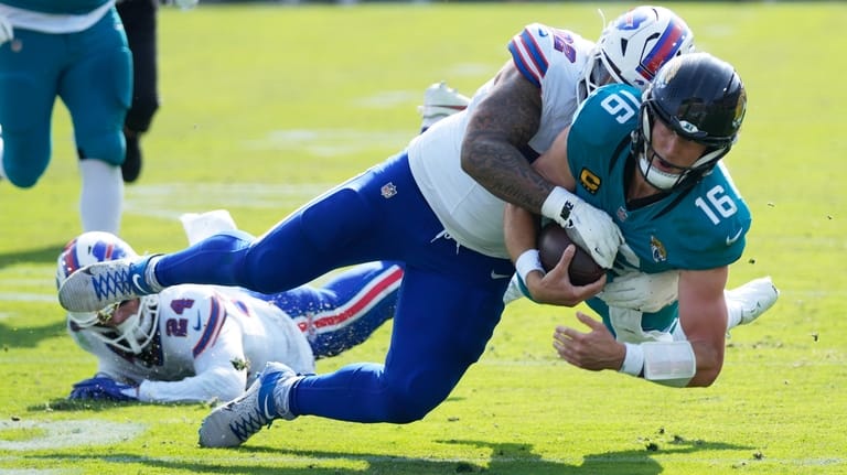 Jacksonville Jaguars quarterback Trevor Lawrence (16) is stopped by Buffalo...
