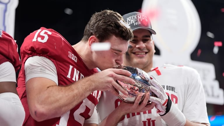 Indiana quarterback Fernando Mendoza (15) kisses the trophy after the...