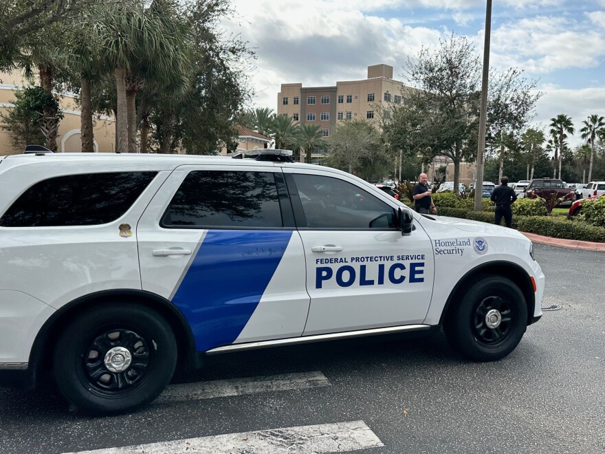 A vehicle from the Department of Homeland Security drives through a parking lot
