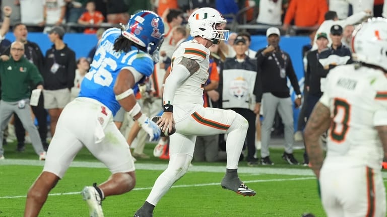 Miami quarterback Carson Beck (11) runs to the end zone...