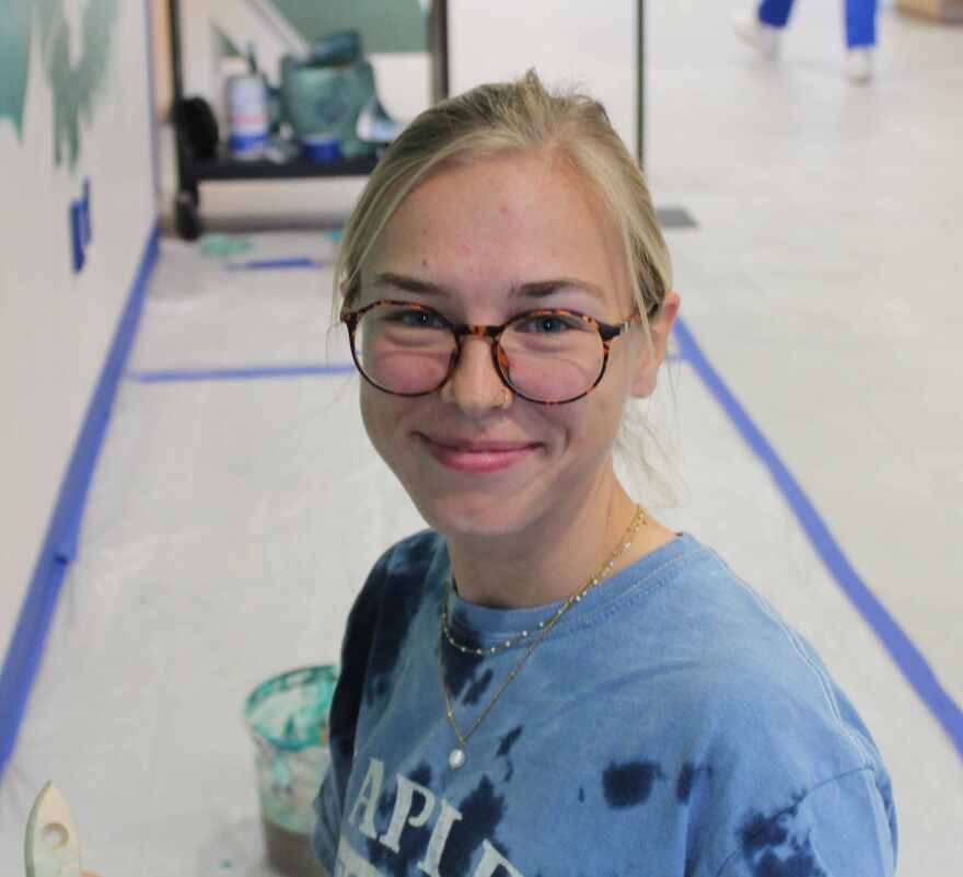 Fifth year FGCU student and muralist Macy Noll at work in the Bradshaw Library at FGCU.