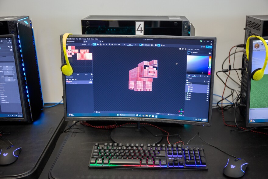 A close up of a computer monitor with a 3D modeling software. It shows a unicorn pig creature in the style of the Minecraft video games. 