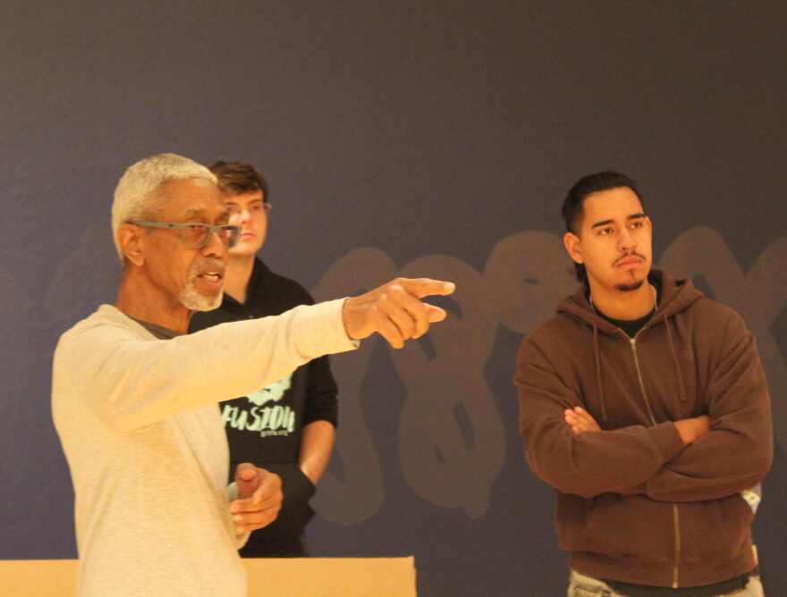 Multidisciplinary artist Onajide Shabaka gives explanations to drummer Nicholas Romig (in black) and trumpeter Diego Figueredo of artwork in 'Becoming Tomorrow's Dreams' exhibition.