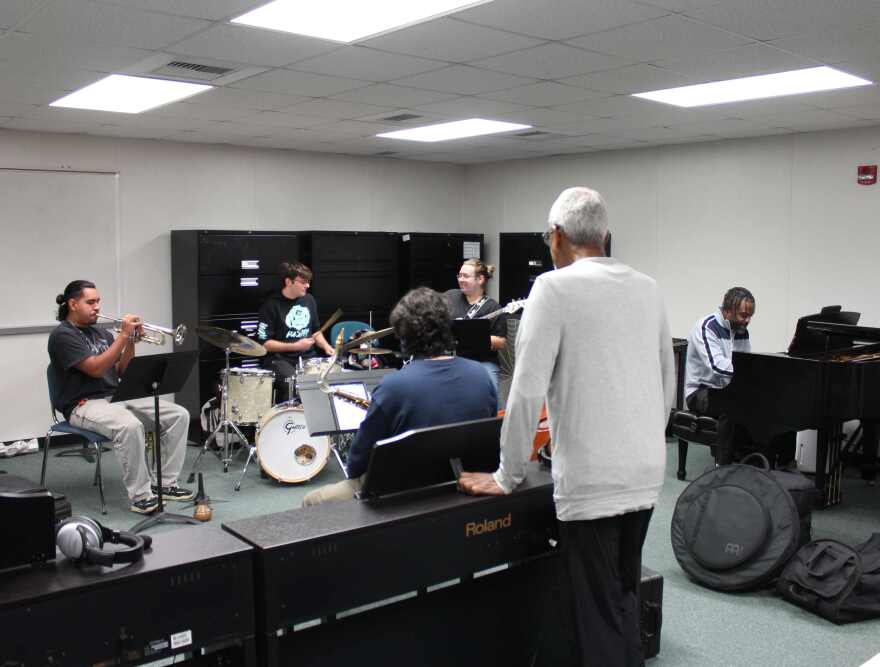 Artist Onajide Shabaka (white shirt, back turned) listens to FGCU Jazz Combo rehearse for February 3 concert in Wasmer Gallery.