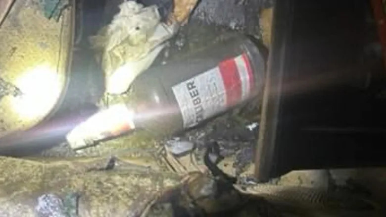 A bottle of liquor inside the burnt car that attempted to keep driving while on fire