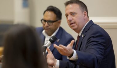 Man speaks with his hands into a microphone