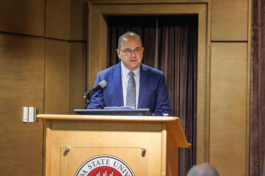 Brad T. Gomez, associate professor and chair of the Department of Political Science, introduces Germany's Ambassador to the U.S. behind a lectern with the FSU seal on it.