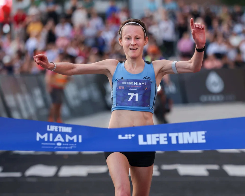 Tracy Barlow of England lifts her arms as she crosses the finishing line to win the Women's Elite Life Time Miami Half Marathon on Sunday, January 25, 2026, in Miami, Florida.