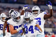 Dallas Cowboys running back Jaydon Blue (34) celebrates a touchdown with center Brock...