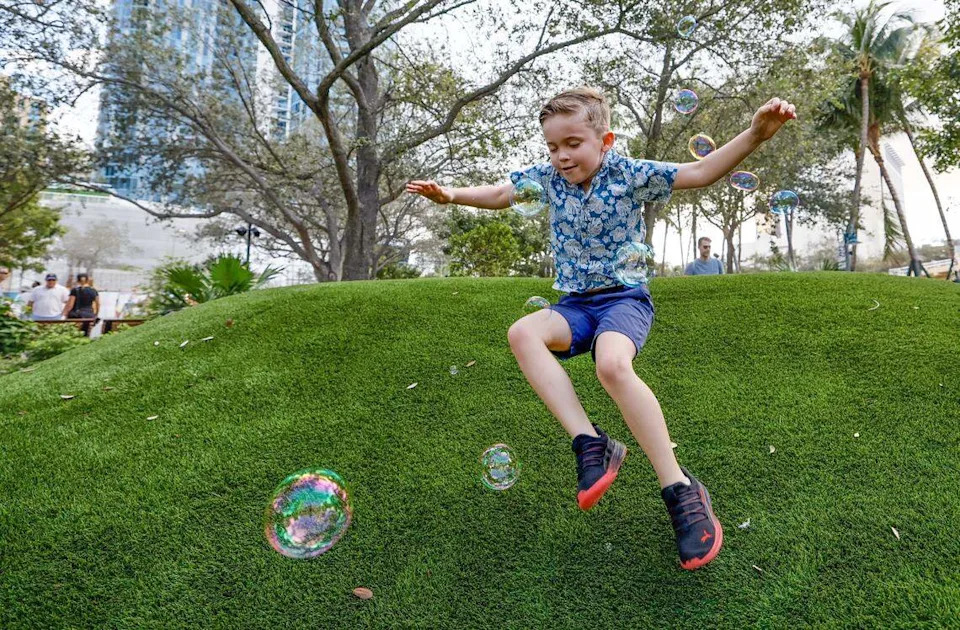 Colton Saye, 6, chases bubbles while running down a mound at Huizenga Park.