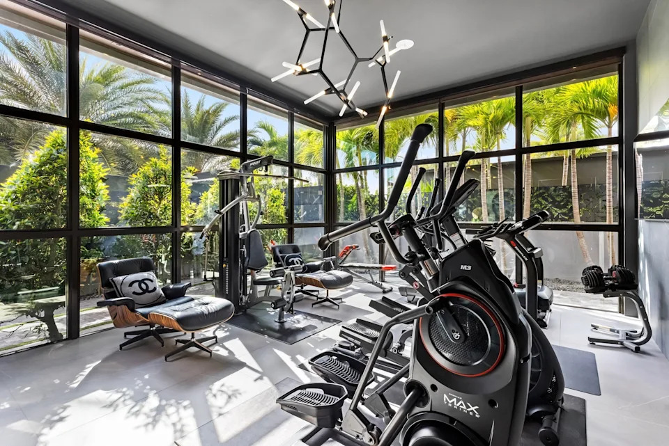 Gym with Chanel pillows in celebrity developer Aldo Stars home in Florida