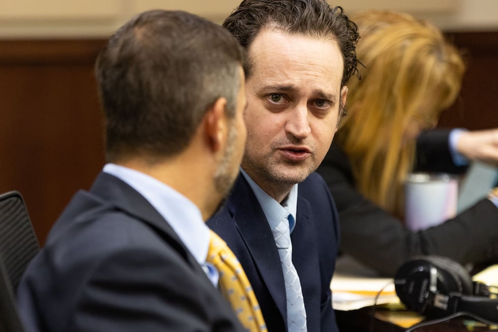 Charlie Adelson talks with his defense attorney Daniel Rashbaum before taking the stand to...