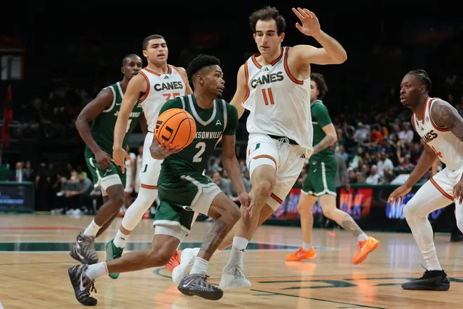 Nov 3, 2025; Coral Gables, Florida, USA; Jacksonville Dolphins guard Jaylen Jones (2) drives to the basket against Miami Hurricanes center Salih Altuntas (11) during the second half at Watsco Center.