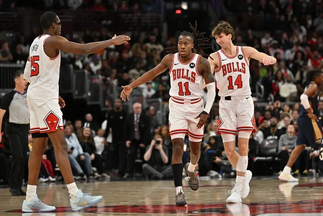 Dec 31, 2025; Chicago, Illinois, USA; Chicago Bulls guard Ayo Dosunmu (11) celebrates his three point shot with forward Jalen Smith (25) and forward Matas Buzelis (14) against the New Orleans Pelicans during the second half at United Center.