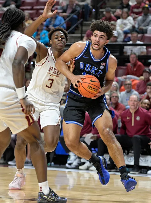 Jan 3, 2026; Tallahassee, Florida, USA; Duke Blue Devils forward Cameron Boozer (12) drives to the net past Florida State Seminoles forward Thomas Bassong (3) during the first half at Donald L. Tucker Center. Mandatory Credit: Melina Myers-Imagn Images