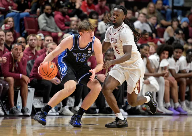 Jan 3, 2026; Tallahassee, Florida, USA; Duke Blue Devils guard Nikolas Khamenia (14) drives to the basket Florida State Seminoles guard Robert McCray (6) during the first half at Donald L. Tucker Center. Mandatory Credit: Melina Myers-Imagn Images