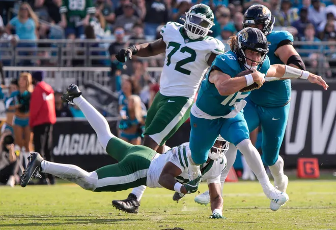 Jacksonville Jaguars cornerback Jabbar Muhammad (37) tries to tackle Jacksonville Jaguars quarterback Trevor Lawrence (16) during the second quarter during an NFL football game at EverBank Stadium, Sunday, Dec. 14, 2025, in Jacksonville, Fla.