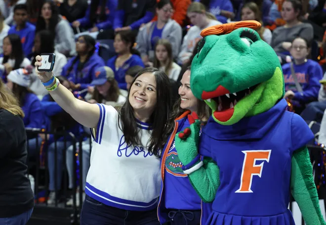 Former gymnasts grab a selfie with Florida mascot Alberta before a meet against Alabama at Steven C. O'Connell Center Exactek arena in Gainesville, FL on Friday, January 16, 2026. [Alan Youngblood/Gainesville Sun]