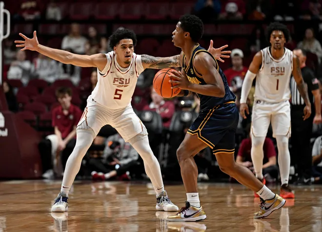 Jan 28, 2026; Tallahassee, Florida, USA; California Golden Bears Dai Dai Ames (7) looks to pass as Florida State Seminoles guard Kobe MaGee (5) defends during the first half at Donald L. Tucker Center. Mandatory Credit: Melina Myers-Imagn Images