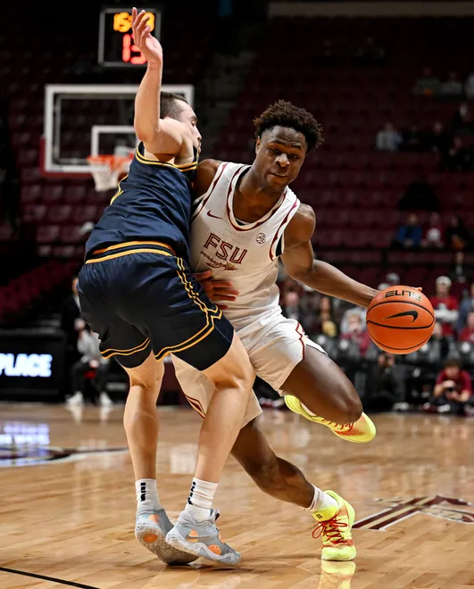 Jan 28, 2026; Tallahassee, Florida, USA; Florida State Seminoles forward Thomas Bassong (3) drives to the net past the defense of California Golden Bears forward John Camden (2) during the first half at Donald L. Tucker Center. Mandatory Credit: Melina Myers-Imagn Images