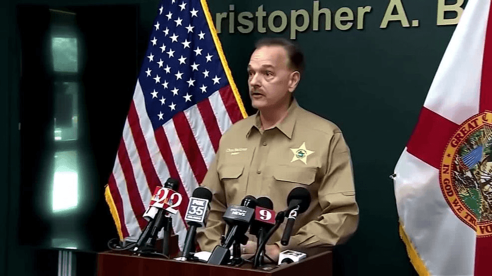 A 29‑year‑old man was arrested Sunday after authorities say he carried out a triple homicide in the Indian Point subdivision near Kissimmee. Deputies found three vacationing men — Douglas Kraft, Robert Kraft and James Puchon — shot to death in front of a home on Indian Point Circle shortly after noon on Jan. 18. Investigators quickly identified the suspect as Ahmad Jihad Bojeh, who was detained in a neighboring house and charged with three counts of murder. Sheriff Christopher Blackmon described the attack as random, unprovoked, and “cold‑blooded,” noting there had been no conflict between Bojeh and the victims. Records referenced by investigators show Bojeh previously had contact with law enforcement, including a 2021 incident in which he was seen firing at cars, though he was later found not guilty by reason of insanity. Blackmon credited deputies’ fast response for preventing more casualties, saying the quick action kept Bojeh from harming others. The investigation remains ongoing. (WFTV | CNN Newsource)