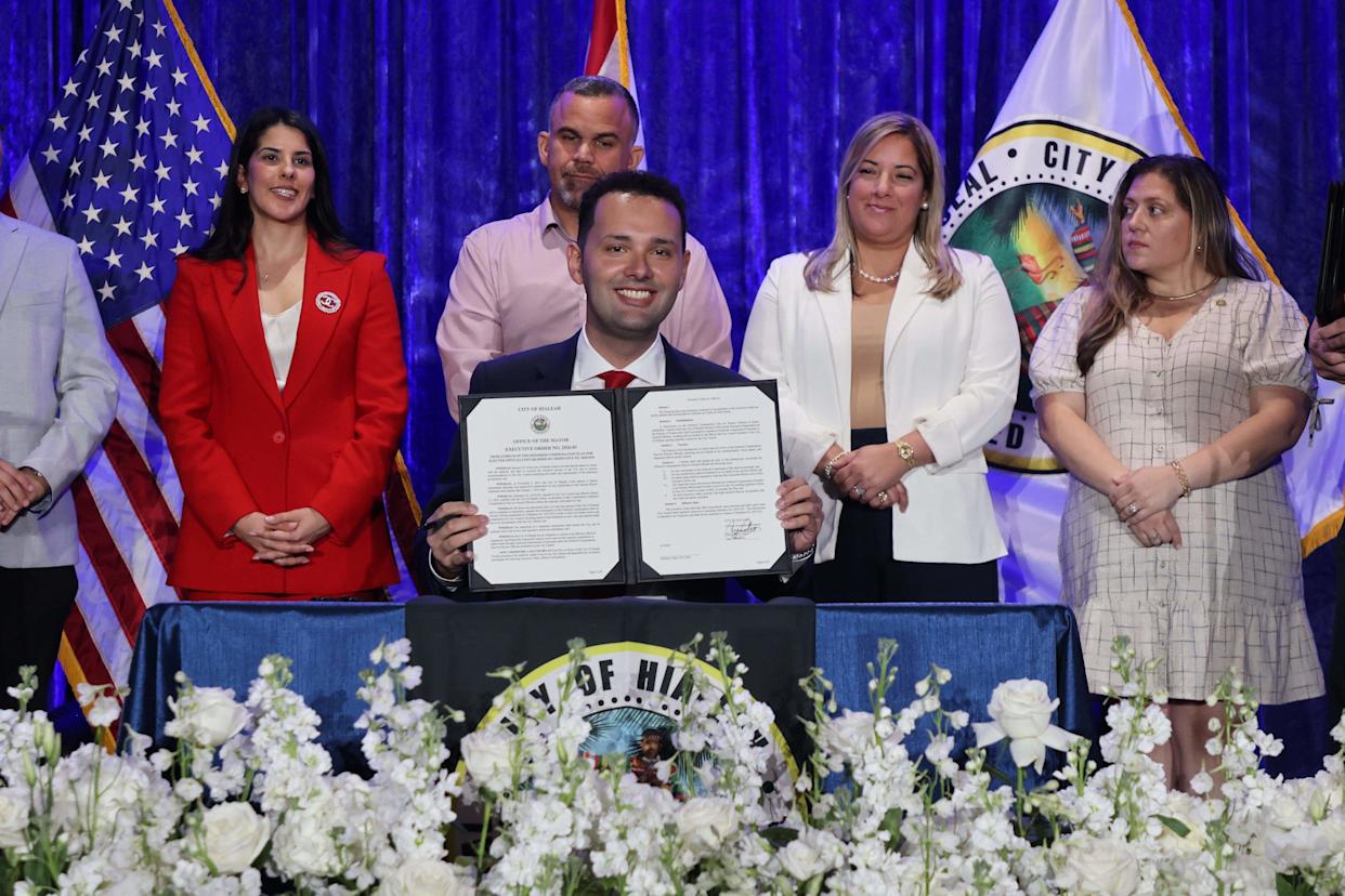Bryan Calvo, 28, center, shows his signature on his first executive order after being sworn in as mayor of Hialeah at the Milander Center on Monday, Jan. 12, 2026, in Hialeah.