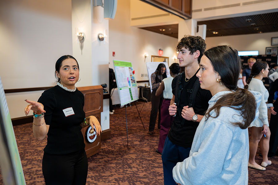 Emma Clark, a junior earning degrees in Political Science and Philosophy, discusses her project with attendees at the 2025 Global Scholars Showcase. (Brittany Mobley/Division of Undergraduate Studies)