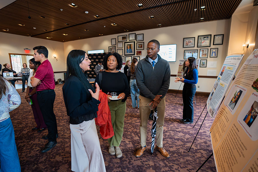 Natalia Arroyo, who graduated in the fall with a bachelor’s degree in Social Work and another one in Political Science, discusses her project with attendees at the 2025 Global Scholars Showcase. (Brittany Mobley/Division of Undergraduate Studies)