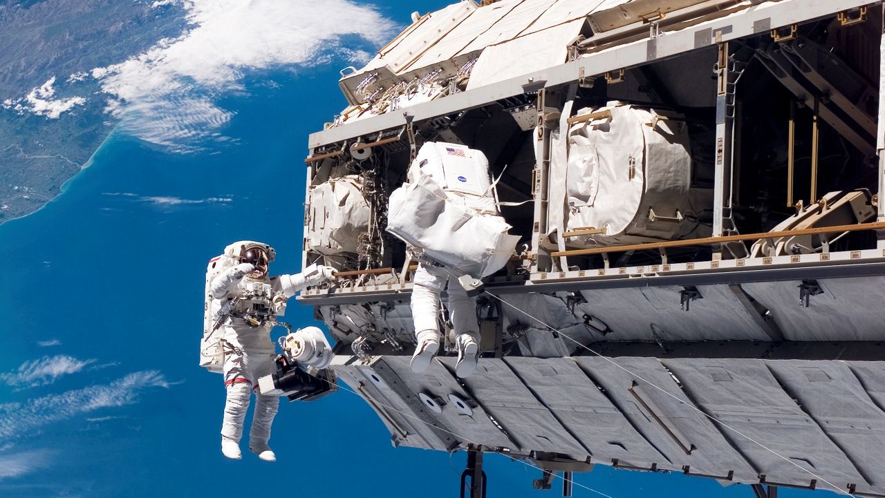 FILE - In this photo provided by NASA, astronaut Robert L. Curbeam Jr., left, and European Space Agency astronaut Christer Fuglesang, participate in a spacewalk during construction of the International Space Station on Dec. 12, 2006. In the background are New Zealand and the Pacific Ocean. (NASA via AP, File)