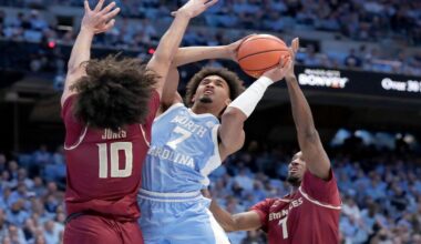 North Carolina guard Seth Trimble (7) drives between Florida State guard Lajae Jones (10) and forward Chauncey Wiggins, right, during the first half of an NCAA college basketball game Tuesday, Dec. 30, 2025, in Chapel Hill, N.C. (AP Photo/Chris Seward)