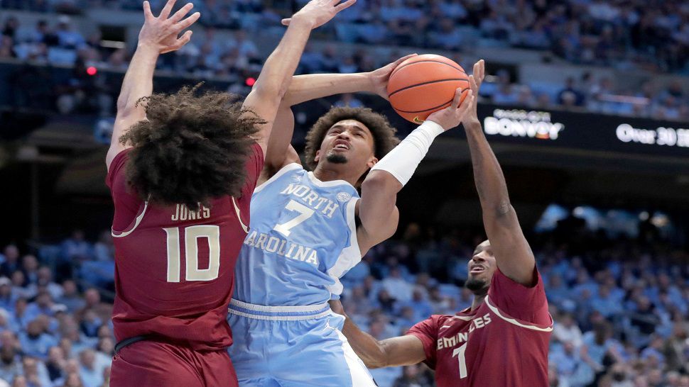North Carolina guard Seth Trimble (7) drives between Florida State guard Lajae Jones (10) and forward Chauncey Wiggins, right, during the first half of an NCAA college basketball game Tuesday, Dec. 30, 2025, in Chapel Hill, N.C. (AP Photo/Chris Seward)
