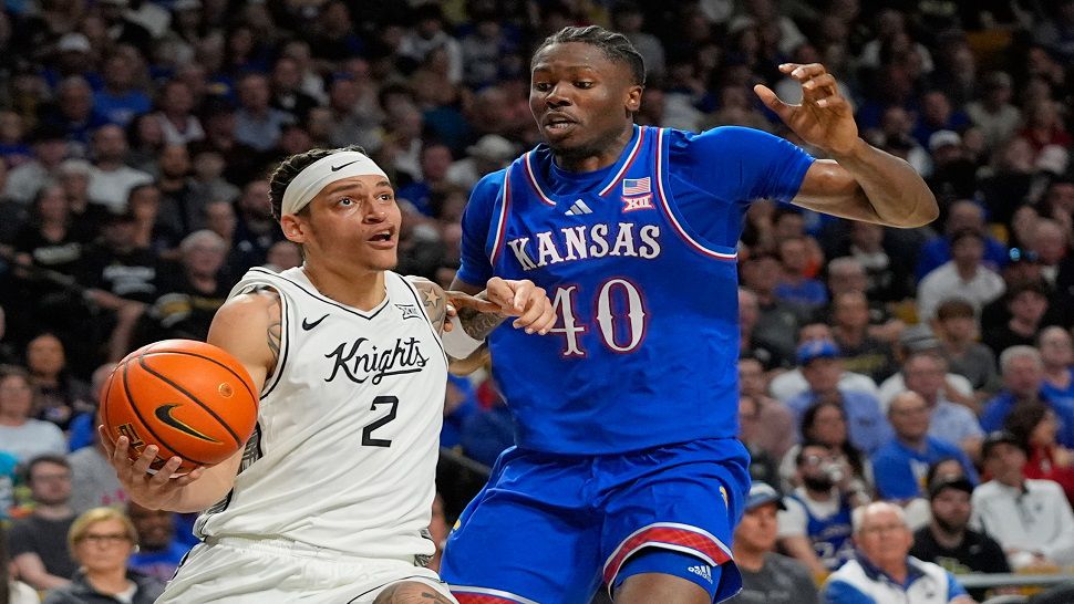 Central Florida guard Riley Kugel (2) gets past Kansas forward Flory Bidunga (40) for a shot during the second half of an NCAA college basketball game, Saturday, Jan. 3, 2026, in Orlando, Fla. (AP Photo/John Raoux)