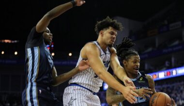 Orlando Magic forward Noah Penda, center, Memphis Grizzlies forward Cedric Coward, left and Memphis Grizzlies guard Ja Morant, right, fight for the ball during the first half of an NBA basketball game Sunday, Jan. 18, 2026, in London. (AP Photo/Kin Cheung)