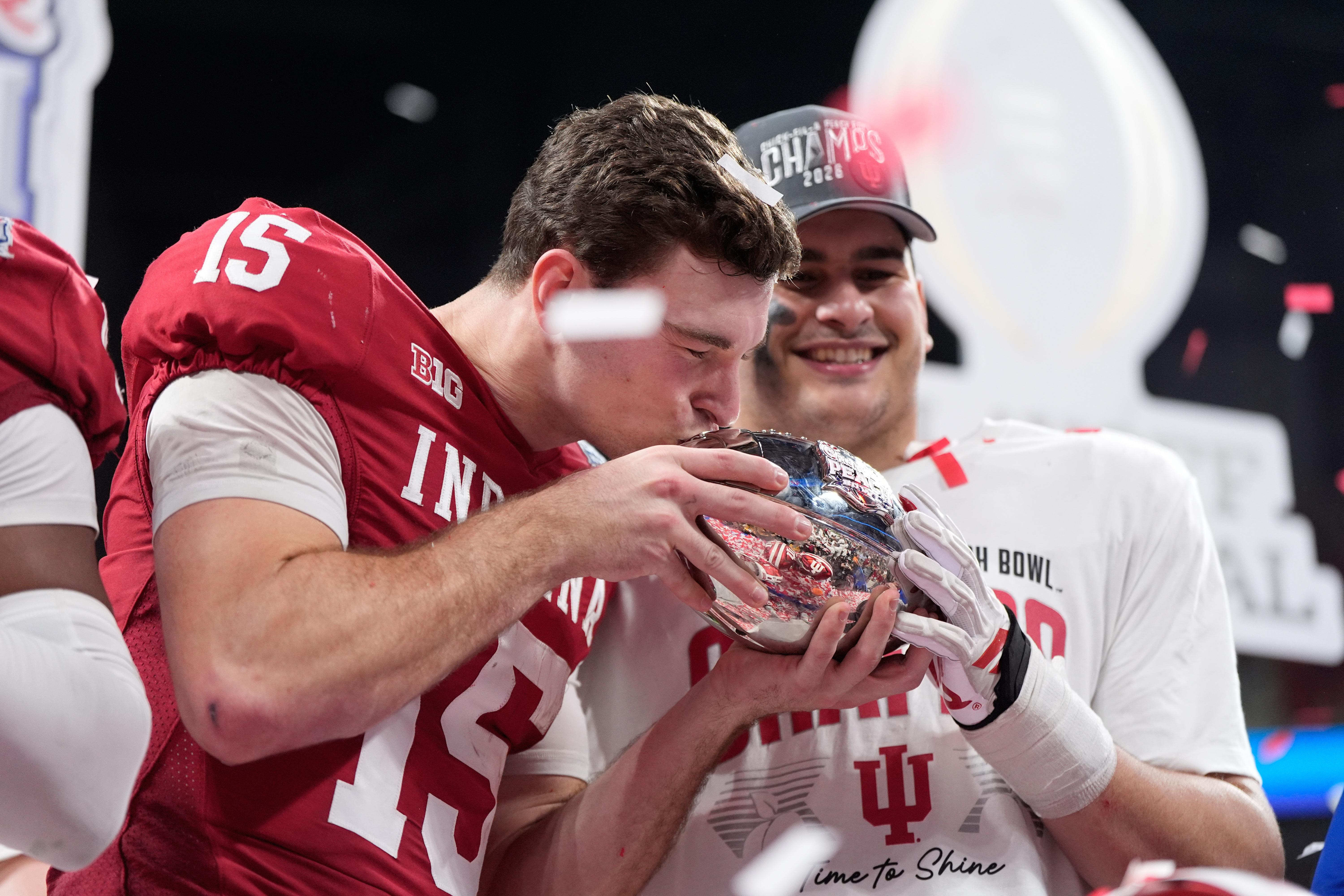 Indiana quarterback Fernando Mendoza (15) kisses the trophy after the...