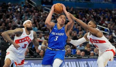 Orlando Magic guard Desmond Bane, center, drives against Toronto Raptors forward Brandon Ingram, left, and forward RJ Barrett during the first half of an NBA basketball game, Friday, Jan. 30, 2026, in Orlando, Fla. (AP Photo/John Raoux)