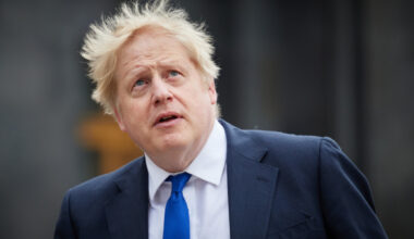 A white man with tousled hair looking up to the sky.
