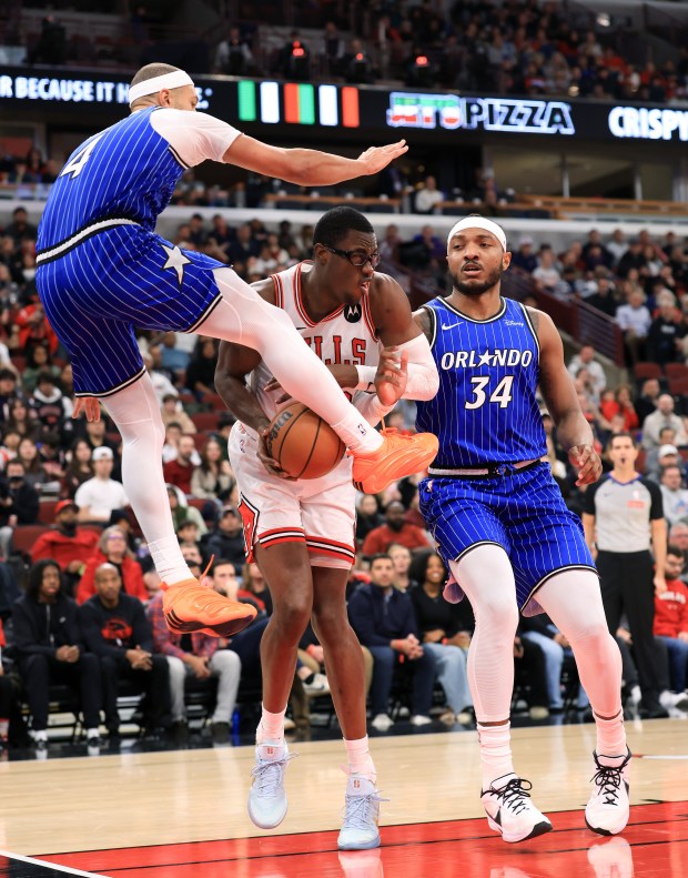 Bulls forward Jalen Smith, center, is defended by Magic guard Jalen Suggs, left, and center Wendell Carter Jr. in the first quarter at the United Center on Jan. 2, 2026, in Chicago. (John J. Kim/Chicago Tribune)