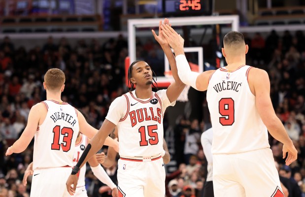 Bulls forward Julian Phillips (15) gets a high five from center Nikola Vučević after a dunk in the fourth quarter against the Magic at the United Center on Jan. 2, 2026, in Chicago. (John J. Kim/Chicago Tribune)