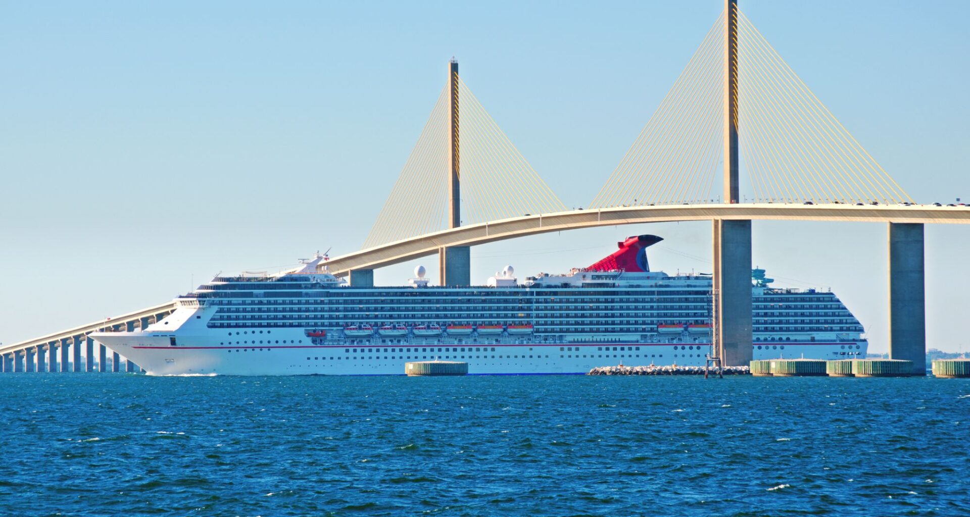 Carnival ship sailing under Tampa Sunshine Skyway Bridge