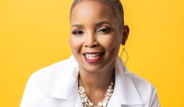professional headshot of a woman in a white button-down in front of a bright yellow backdrop